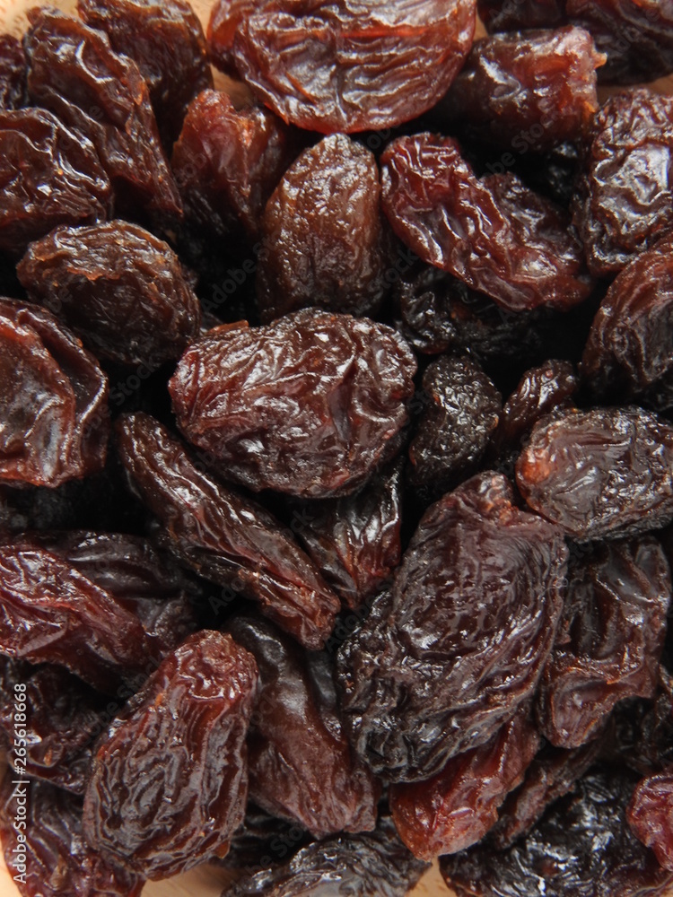 Top view of dried raisins background. Dry food. It tastes sweet and delicious. Raisins are usually eaten as snacks or added to pastries or biscuit. Texture detail of raisin surface. Food concept Top view of dried raisins background. Dry food. It tastes sweet and delicious. Raisins are usually eaten as snacks or added to pastries or biscuit. Texture detail of raisin surface. Food concept