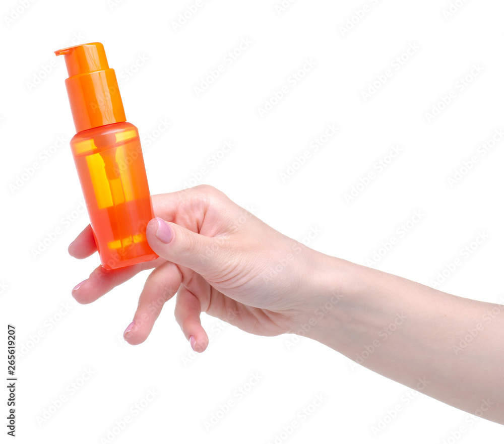 Orange sunscreen suntan bottle in hand on a white background. Isolation Orange sunscreen suntan bottle in hand on a white background. Isolation