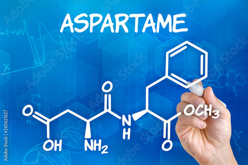 Hand with pen drawing the chemical formula of aspartame photo