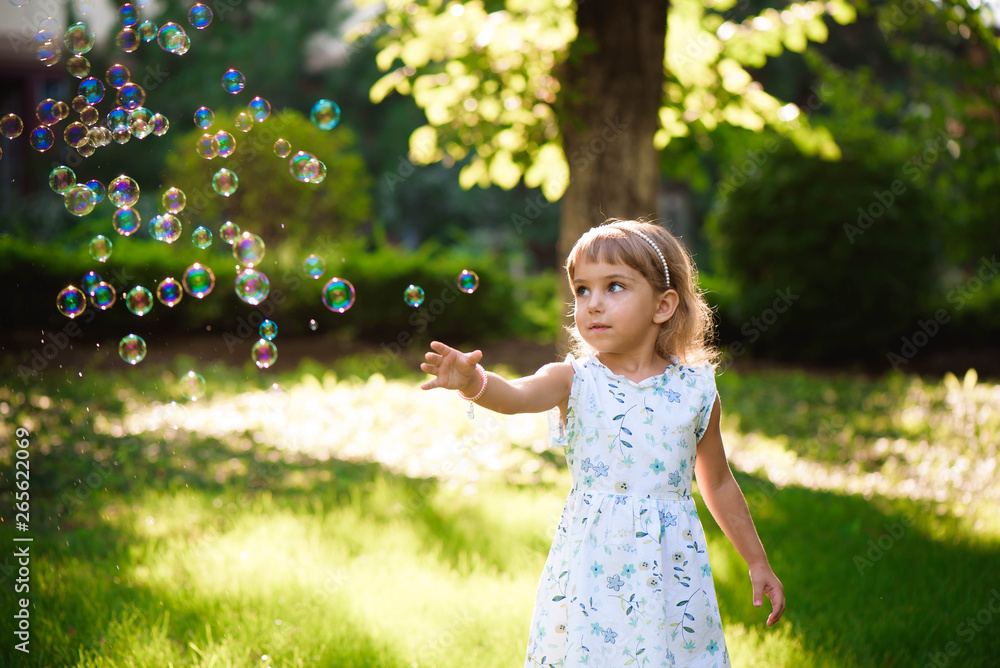 Happy baby girl standing in grass with dandelions Happy baby girl standing in grass with dandelions