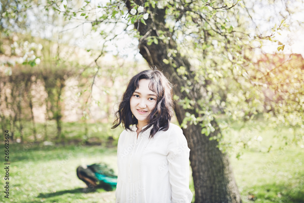 Happy young woman in a white blouse in a park. Springtime Happy young woman in a white blouse in a park. Springtime