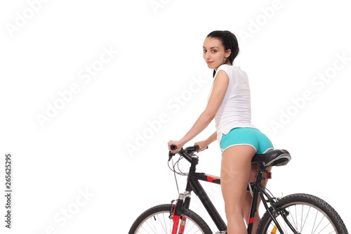 Young seductive woman in sport wear posing on the bicycle