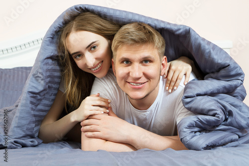 Happy couple is lying in bed together