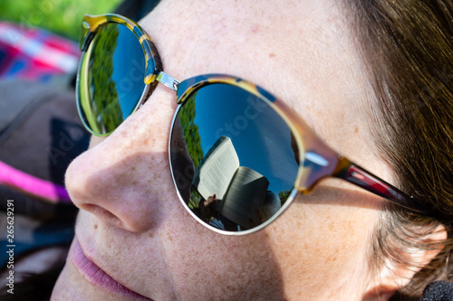 Foto Reflet d'un livre sur les lunettes de soleil d'une femme