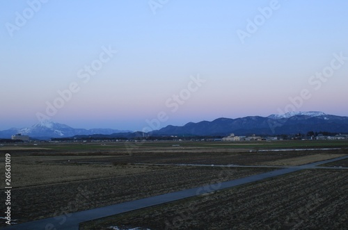 冬の田畑の風景と滋賀県の名峰、伊吹山の雪化粧した様子です