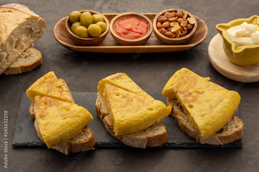 Spanish omelette cut on bread with toasted peanuts olives and tomato fried Spanish omelette cut on bread with toasted peanuts olives and tomato fried