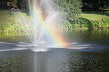 Rainbow in fountain in city pond in the park