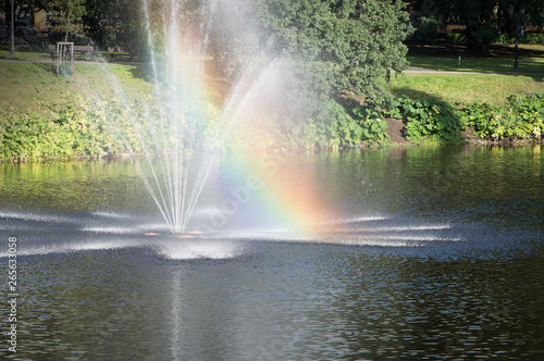 Rainbow in fountain in city pond in the park