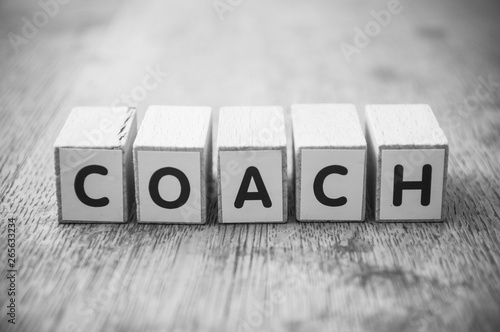 Photo Closeup of word on wooden cube on wooden desk background concept - coach