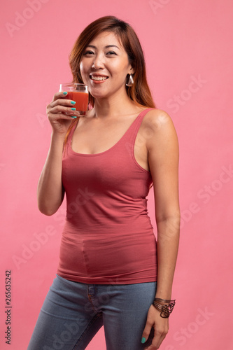 Young Asian woman drink tomato juice.