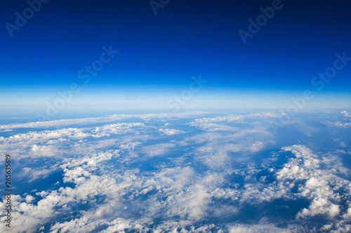 View of the Mediterranean sea from an airplane. Aerial photography from an airplane window. Beautiful blue sea landscape with white fluffy clouds, waves for print, poster, cover, surface, web design