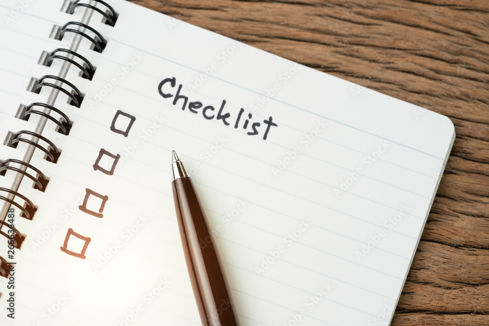 Checklist, to do list, prioritize or reminder for project plan, selective focus on pen with handwriting headline the word Checklist and check box on small notepad on wood table Checklist, to do list, prioritize or reminder for project plan, selective focus on pen with handwriting headline the word Checklist and check box on small notepad on wood table