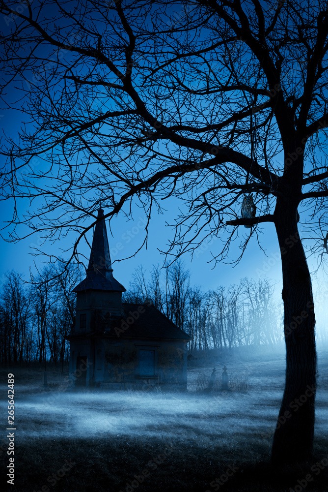 Old chapel on haunted creepy graveyard at night