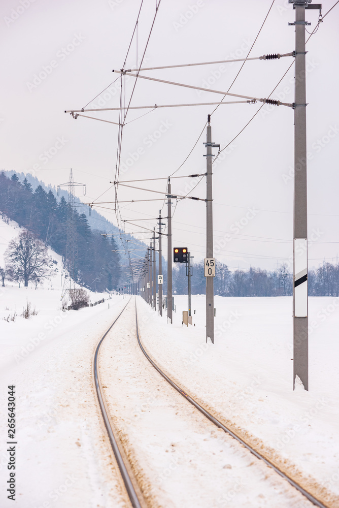 Railway power lines and the snow-covered fields in a scenic winter mountain landscape, Dachstein massif, Liezen District, Styria, Austria, Europe