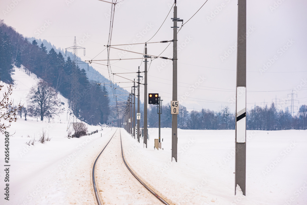 Railway power lines and the snow-covered fields in a scenic winter mountain landscape, Dachstein massif, Liezen District, Styria, Austria, Europe Railway power lines and the snow-covered fields in a scenic winter mountain landscape, Dachstein massif, Liezen District, Styria, Austria, Europe