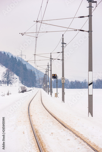 Railway power lines and the snow-covered fields in a scenic winter mountain landscape, Dachstein massif, Liezen District, Styria, Austria, Europe © mckornik