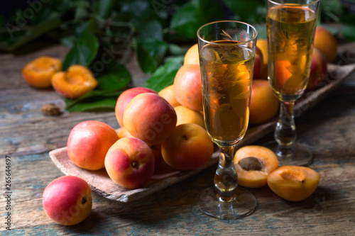 Apricots  and glasses of apricot liqueur old wooden table.