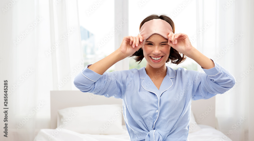 people and bedtime concept - happy young woman in pajama and eye sleeping mask winking over background people and bedtime concept - happy young woman in pajama and eye sleeping mask winking over background