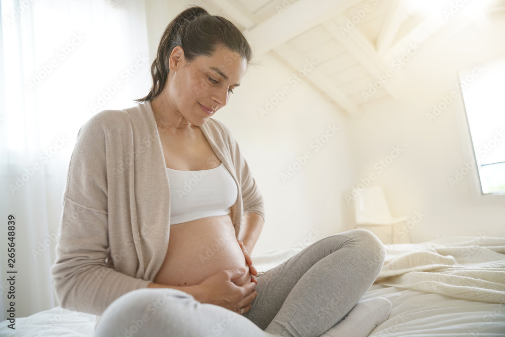 Pregnant woman relaxing on bed