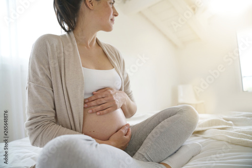 Pregnant woman relaxing on bed