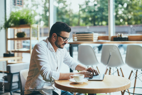 Attractive man working in cafe 