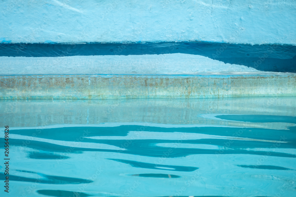 Edge of blue swimming pool with rippled water