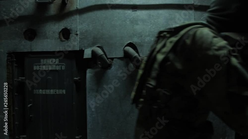 Fully Equipped Soldiers Wearing Camouflage Uniform Attacking Enemy, Rifles Ready to Shoot. Airsoft player in full camouflage passes inside the building.