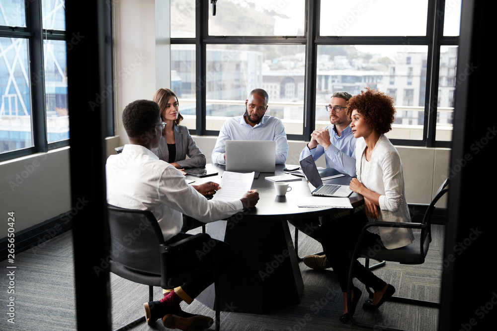 Φωτογραφία Corporate business colleagues talking in a meeting room, seen from doorway