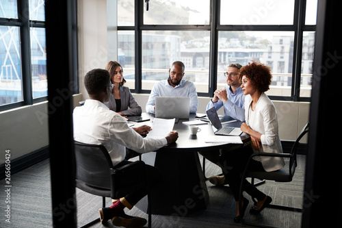 Corporate business colleagues talking in a meeting room, seen from doorway photo