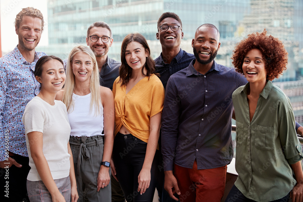 Fototapeta premium Group portrait of a creative business team standing outdoors, three quarter length, close up