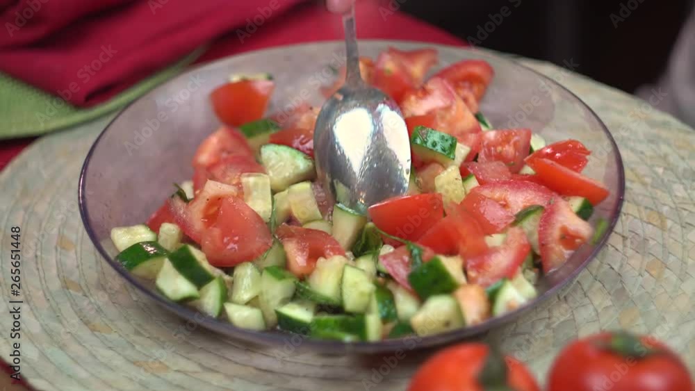 The chef mixes a salad of fresh tomatoes and cucumbers with herbs, close-up, healthy eating, chef, cooking The chef mixes a salad of fresh tomatoes and cucumbers with herbs, close-up, healthy eating, chef, cooking