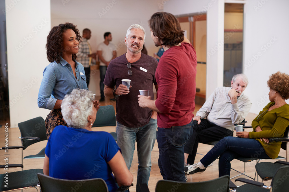 Group Of People Socializing After Meeting In Community Center Group Of People Socializing After Meeting In Community Center