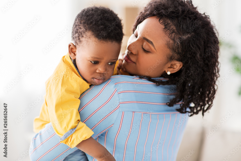 Obraz premium childhood, kids and people concept - african american mother with her sad baby son at home