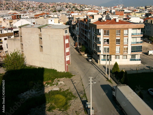 Dicht bebaute Wohnsiedlung in Beige und Naturfarben am Berghang mit modernen Hochhäusern im Sommer bei Sonnenschein im Stadtteil Cigli in Izmir am Ägäischen Meer in der Türkei photo