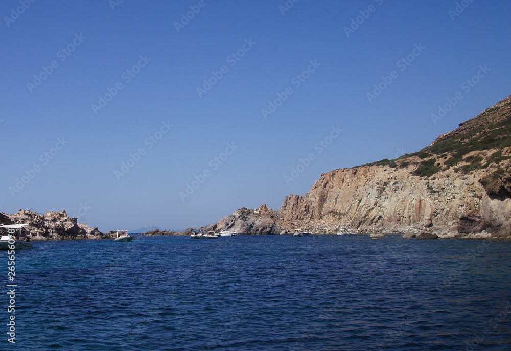 View of the white and yellow mountains of the cliffs growing from the sea on the shore from a boat. Blue Lagoon.