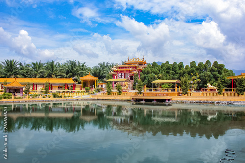 View of a beautiful chinese temple and a clear pond in Seen Hock Yeen Confucius Temple in Chemor, Perak, Malaysia from flowery walkways.