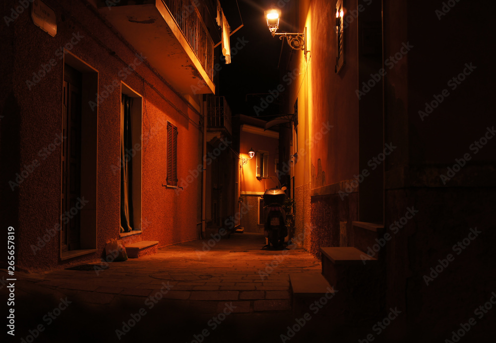 Night cityscape evening streets with yellow glowing lanterns. Italian old medieval european architecture.