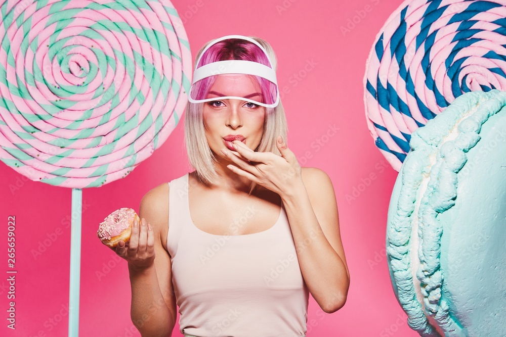 Beautiful girl posing with sweets at pink background Beautiful girl posing with sweets at pink background