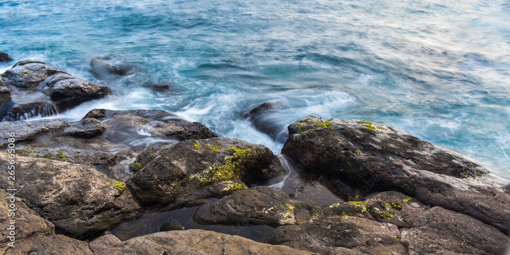 Long exposure of the waves crash on the rocks.