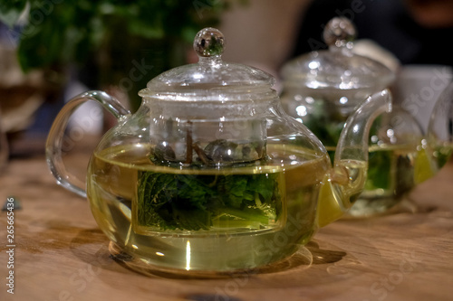Herbal infusion with fresh mint leaves, in clear glass tea pot.
