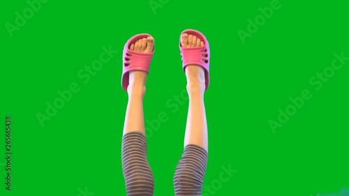 Baby feet in rubber flip-flops on green background. Movement in the air. Bare feet. Light skin. Girl's body. Without a face. The video in 4K.