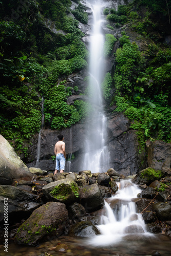 Beautiful scene of Semirang Waterfall with lovely smooth water. A man standing and enjoying a gorgeous waterfall. A Waterfall which is a tourist destination in the city of Ungaran