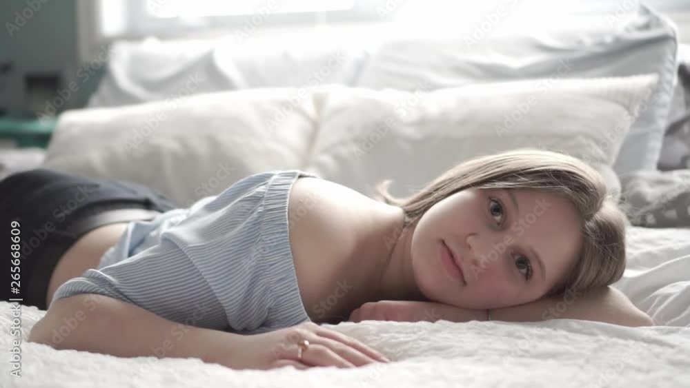 A teenage girl lying in bed and relaxing A teenage girl lying in bed and relaxing
