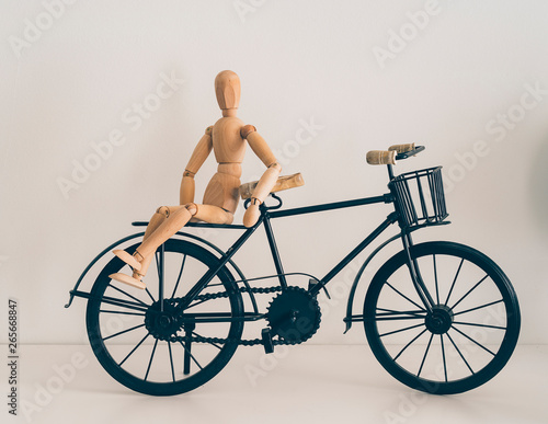 Wooden figure posing in a bicycle, travel and lifestyle.