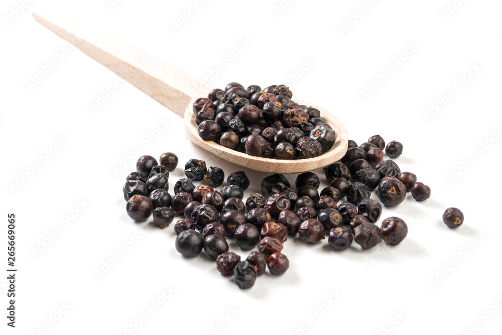 juniper berries on wooden spoon on white background juniper berries on wooden spoon on white background
