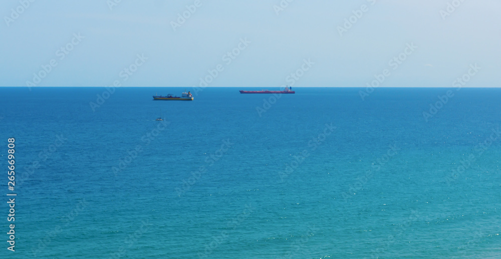 blue sea surface with small ships on the horizon blue sea surface with small ships on the horizon