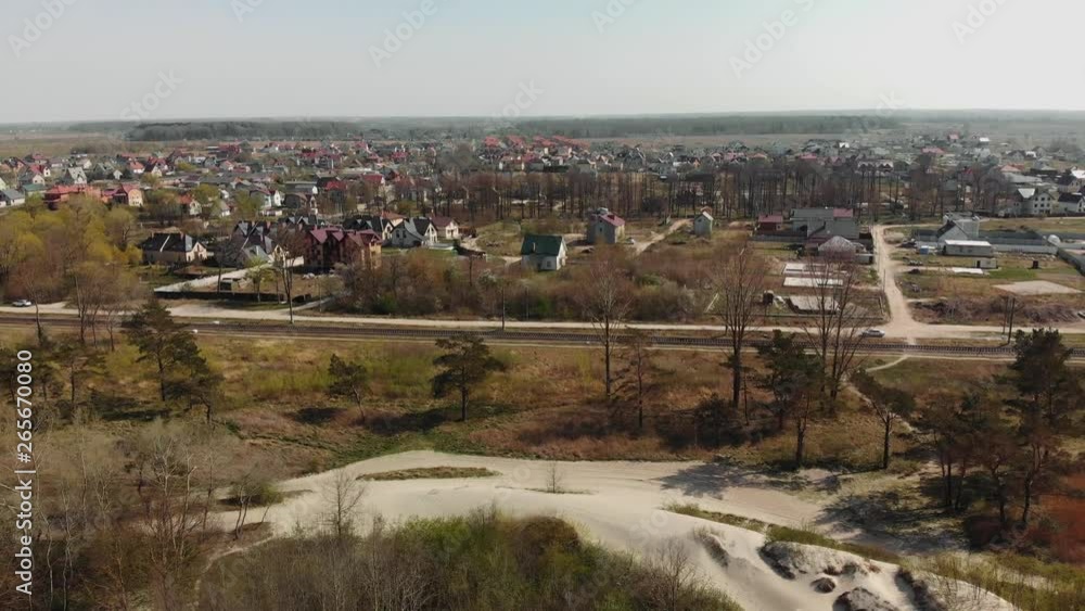 View from a flying drone. Panorama of the village next to the sand dunes with a green forest and blue sea. Bright sunny day View from a flying drone. Panorama of the village next to the sand dunes with a green forest and blue sea. Bright sunny day