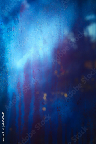 Old dirty dusty window glass with mystical reflection. Soft focus. Abstract background with scratches. Blue and magenta color.