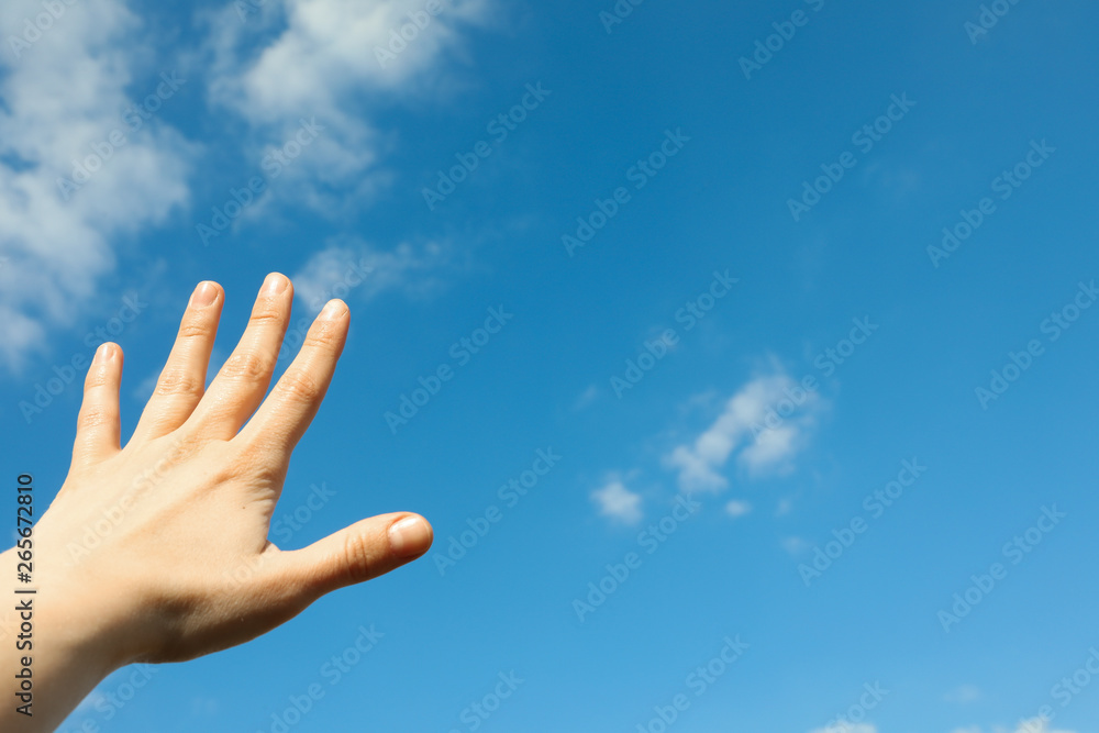Beautiful white fluffy clouds on a light blue sky background with woman hand. Wonderful skies Beautiful white fluffy clouds on a light blue sky background with woman hand. Wonderful skies