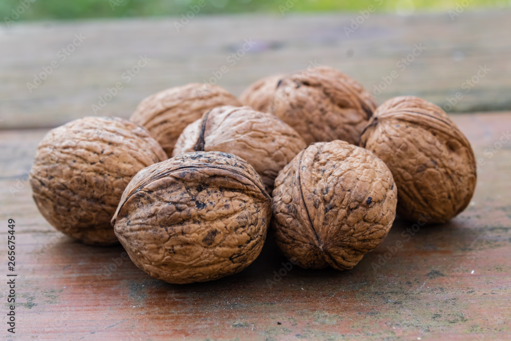 unopened walnuts, with wooden bottom and green trees unopened walnuts, with wooden bottom and green trees